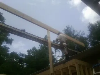 Carpenter setting a ridge beam over a new addition frame — Ice Dam Removal by Roofing Brothers in Norwalk