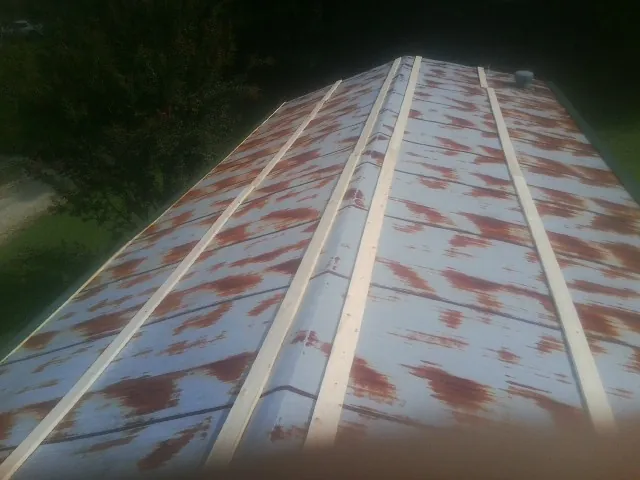 Rusted metal roof panels with new wood purlins before replacement — Storm Damage Roof Repair in Norwalk by Roofing Brothers