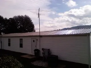 New metal roof on a single wide mobile home with a TV antenna in Norwalk